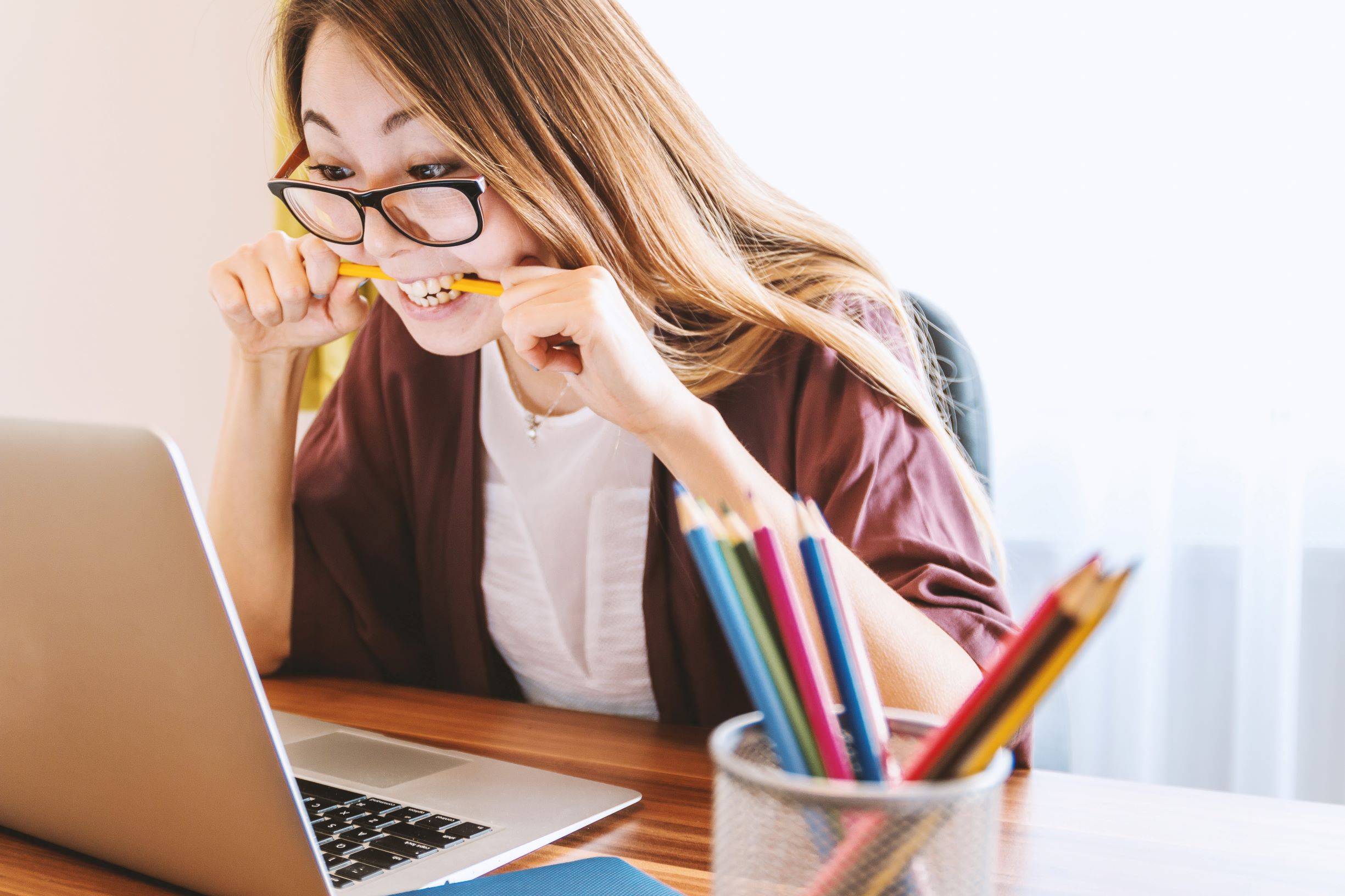 Burned out worker who is biting her pencil with stress